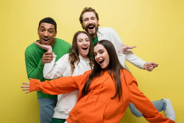 Excited interracial friends having fun on yellow background — Stock Photo