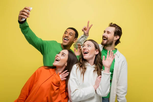 Amici multietnici con videochiamata su smartphone isolato su giallo — Foto stock