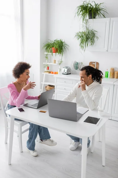 African american freelancers talking near devices in kitchen — Photo de stock