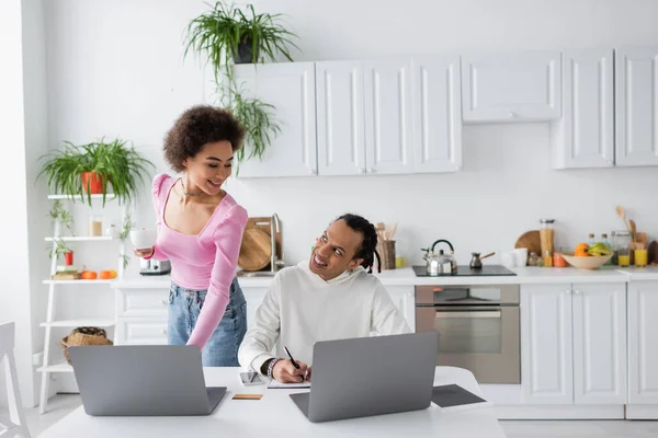 African american couple using laptops in kitchen in morning — Stock Photo