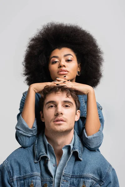 Brunette african american woman looking at camera with stylish man isolated on grey — Stockfoto