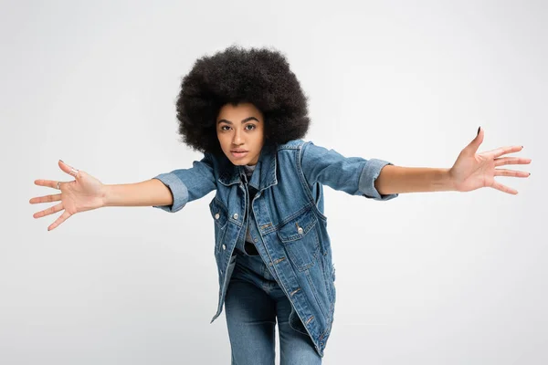 Young african american woman in jeans and denim clothes looking at camera isolated on grey — Stockfoto