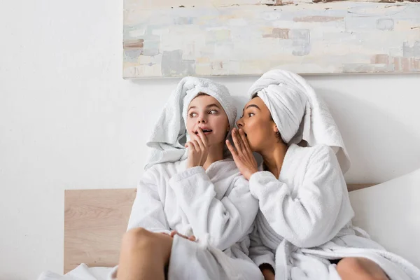 Afroamerikanerin in weißer Robe verrät verblüfften Freund im heimischen Bett ihr Geheimnis — Stockfoto