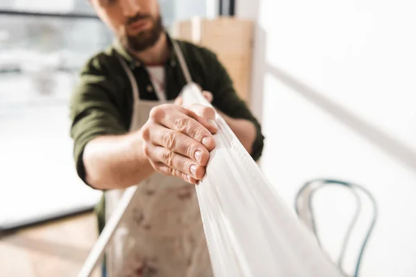 Cropped view of blurred craftsman holding wooden picture frame in workshop — Stock Photo