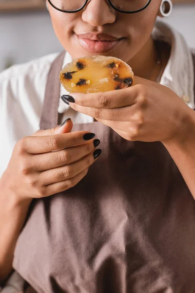 Cropped view of african american craftswoman enjoying flavor of homemade soap in workshop — Foto stock