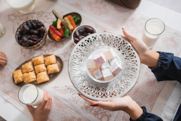 Top view of muslim woman holding turkish delight near child during suhur in morning — Stock Photo