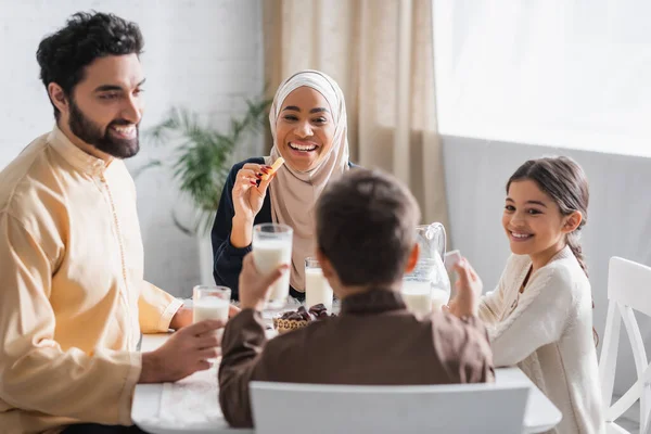 Positive afrikanisch-amerikanische Frau im Hijab hält Cevizli Sucuk nahe Familie in Ramadan Morgen — Stockfoto