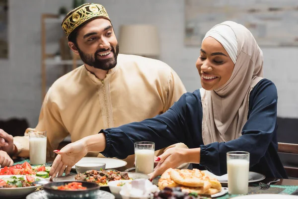 Sorrindo família muçulmana tendo jantar ramadã em casa — Fotografia de Stock