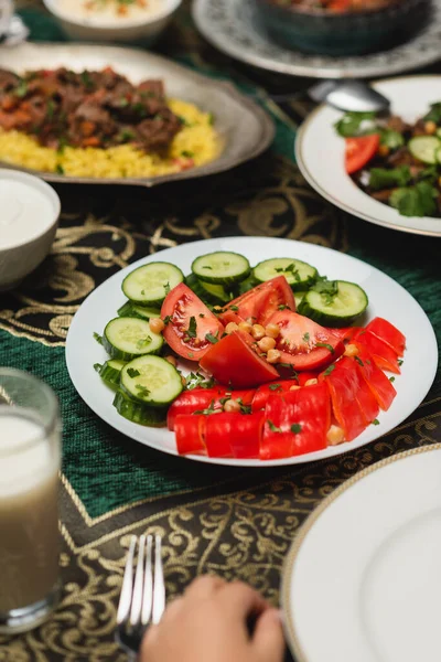 Vista ritagliata del bambino vicino a verdure fresche e alimenti iftar a casa — Foto stock
