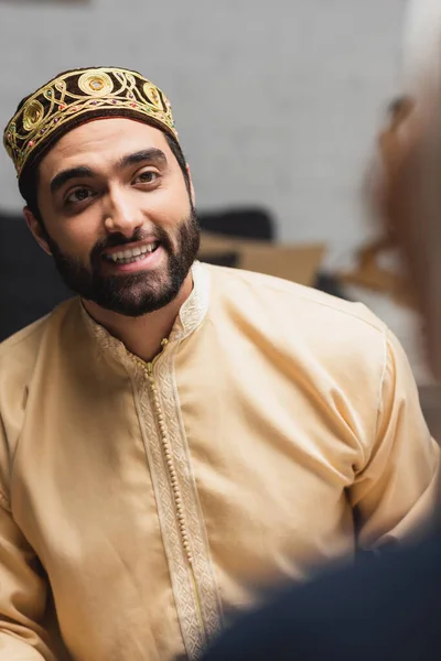 Smiling muslim man looking at blurred wife at home — Photo de stock