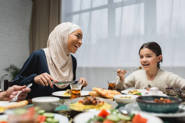 Sonriente familia del Medio Oriente cenando iftar durante el ramadán - foto de stock