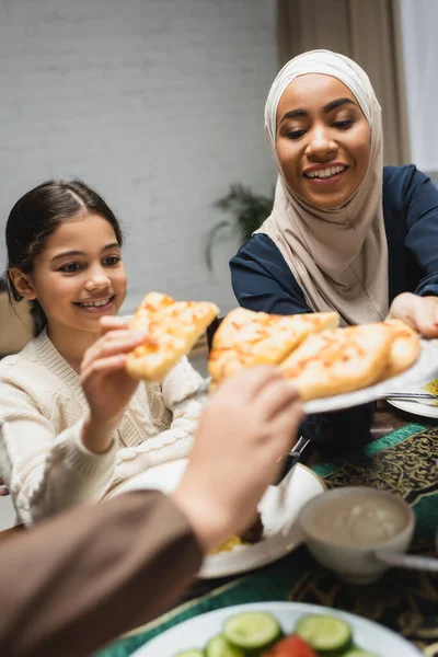 African american woman in hijab holding pita bread near kids during ramadan — Stockfoto