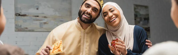 Cheerful muslim family hugging during ramadan dinner at home, banner — Stock Photo
