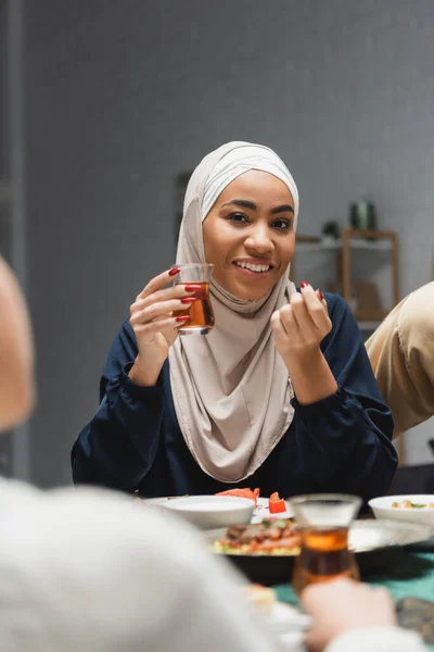 African american woman in hijab holding tea during ramadan dinner at home — Fotografia de Stock