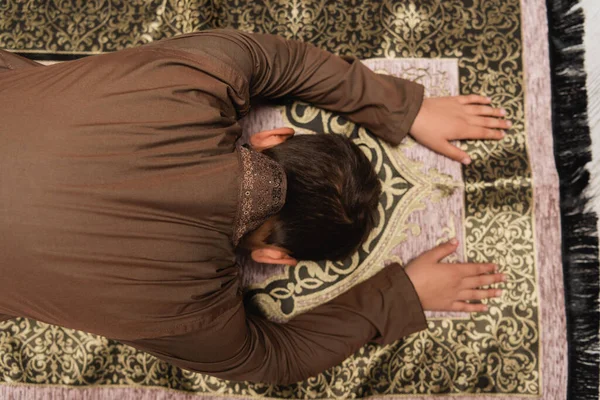 Top view of muslim boy praying on rug at home — Stock Photo