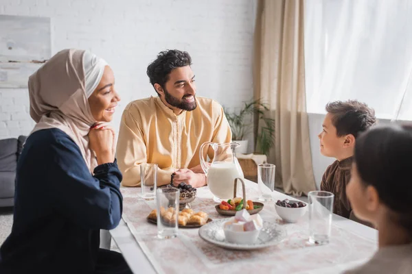 Muslim man holding prayer beads near family and ramadan breakfast at home — Stock Photo