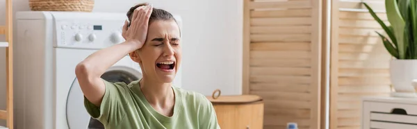 Сумна жінка торкається голови і плаче в пральні, банер — Stock Photo