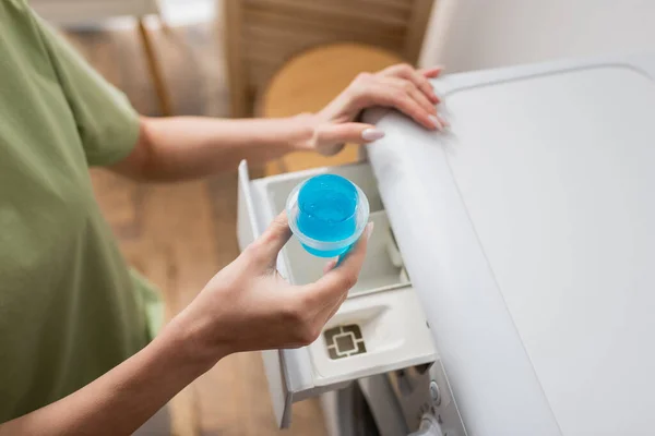 Cropped view of woman holding cap with liquid cleaner near washing machine — Foto stock