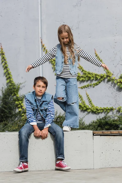 Volle Länge des Mädchens in stilvollem Outfit posiert in der Nähe gut gekleideter Junge und Einkaufszentrum Gebäude — Stockfoto