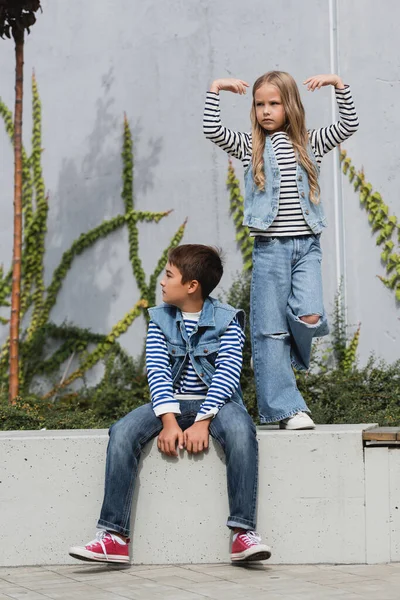 Volle Länge der Mädchen in stilvollen Kleidern posiert in der Nähe gut gekleideten Jungen und Einkaufszentrum Gebäude — Stockfoto