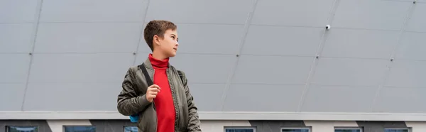 Preteen boy in stylish bomber jacket standing with backpack near mall building, banner — Stockfoto
