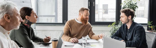 Businessman talking to colleagues during meeting in office, banner — Stock Photo