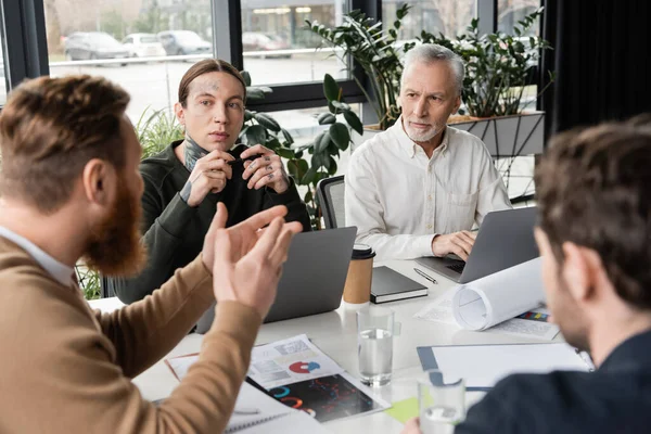 Homme d'affaires flou parlant à ses collègues pendant la formation en affaires au bureau — Photo de stock
