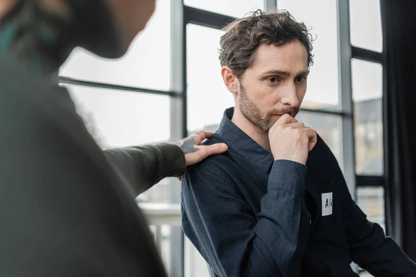 Blurred man calming person with alcohol addiction during meeting in rehab center — Stock Photo