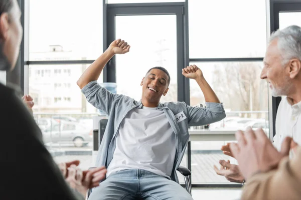 Aufgeregter afrikanisch-amerikanischer Mann mit Alkoholsucht zeigt Ja-Geste während Gruppentherapie — Stockfoto