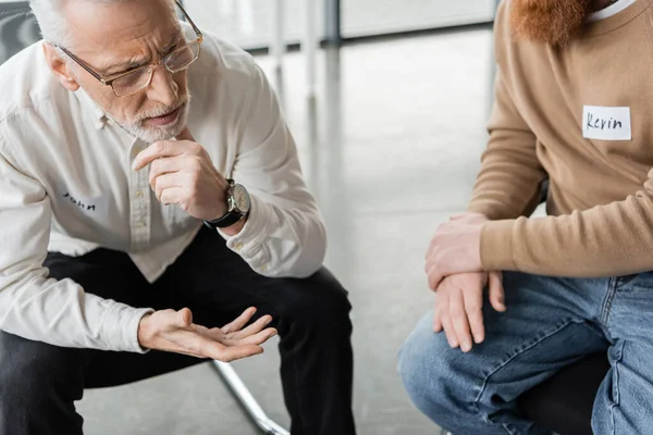 Sad mature man with alcohol addiction sharing problem with group in rehab center — Stock Photo
