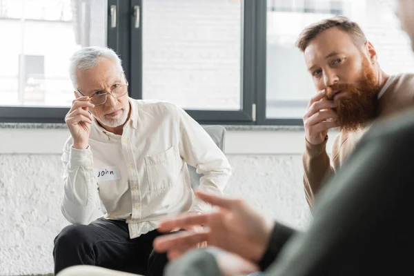 Pessoas a olhar para o homem desfocado durante a reunião de alcoólicos no centro de reabilitação — Stock Photo