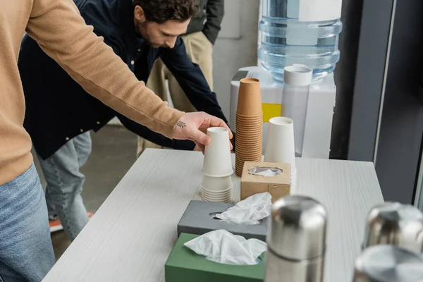 Man with alcohol addiction taking paper cup in rehab center — Stock Photo