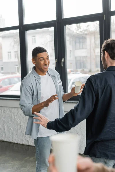 Cheerful interracial men with alcohol addiction talking in recovery center — Stock Photo