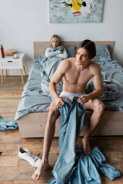 Homme nu pieds et torse nu portant un jean après une nuit debout le matin — Photo de stock