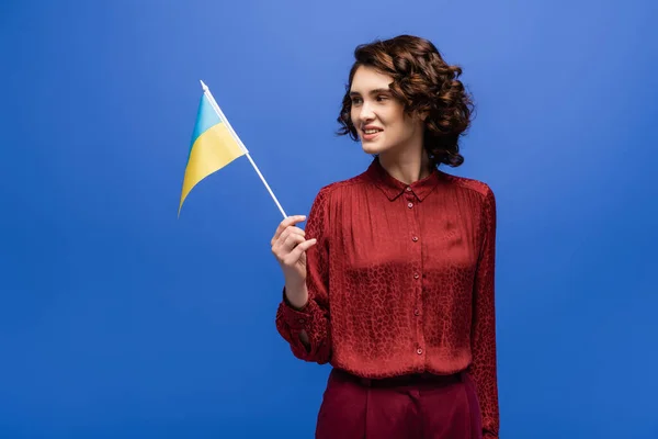 Cheerful language teacher holding flag of Ukraine isolated on blue — Stock Photo