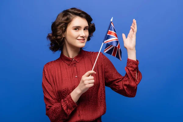 Glückliche Sprachlehrerin mit Flagge Großbritanniens auf blauem Grund — Stockfoto