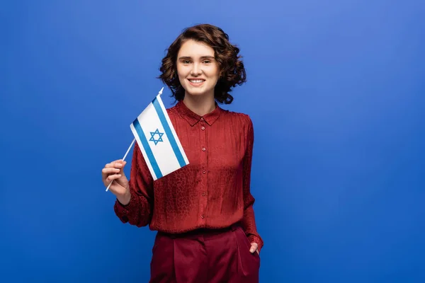 Happy teacher of Hebrew language holding flag of Israel isolated on blue — Stock Photo
