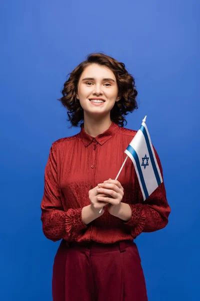 Cheerful teacher of Hebrew language holding flag of Israel isolated on blue — Stock Photo