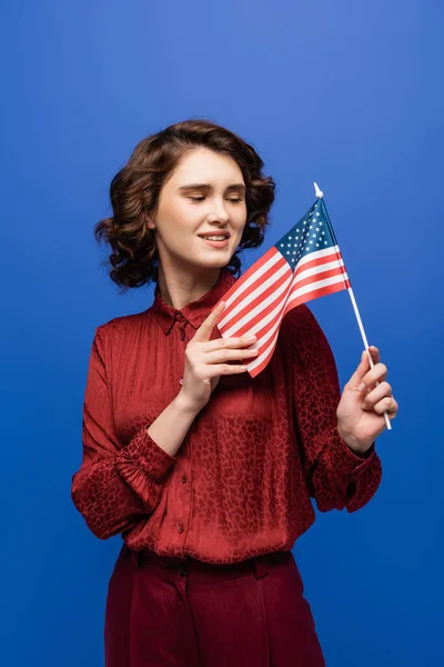 Positive language teacher smiling while looking at usa flag isolated on blue — Stock Photo