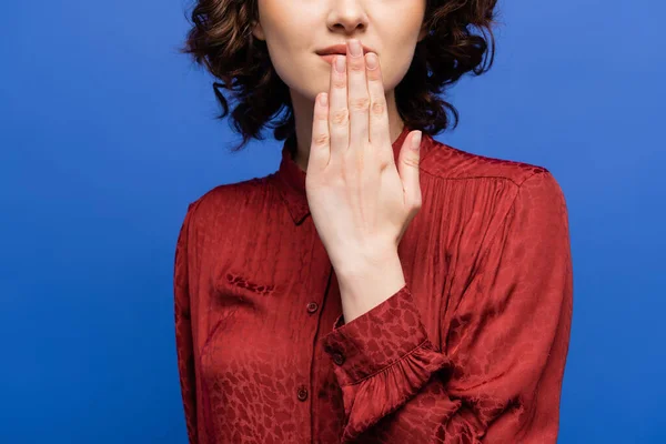 Перекручений погляд на жінку в червоній блузці, яка дякує вам за мову жестів ізольованою на синьому — стокове фото