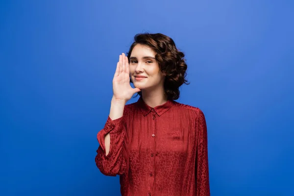 Cheerful teacher showing gesture meaning woman or mother on sign language isolated on blue — Stock Photo