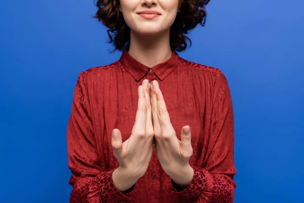 Visión parcial de la mujer feliz hablando en lenguaje de señas aislado en azul - foto de stock