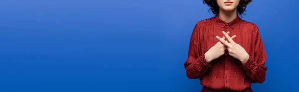 Частичный взгляд учителя в красной блузке жестикулируя на языке жестов изолирован на синий, баннер — стоковое фото