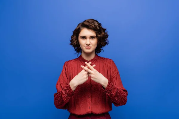 Young teacher looking at camera and showing gesture in sign language isolated on blue — Stock Photo
