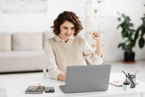Веселая женщина учит говорить на языке жестов во время онлайн-урока на ноутбуке — стоковое фото
