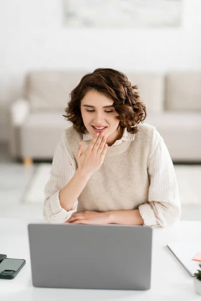 Young sign language teacher smiling while showing thank you gesture during online lesson on laptop at home — Stock Photo