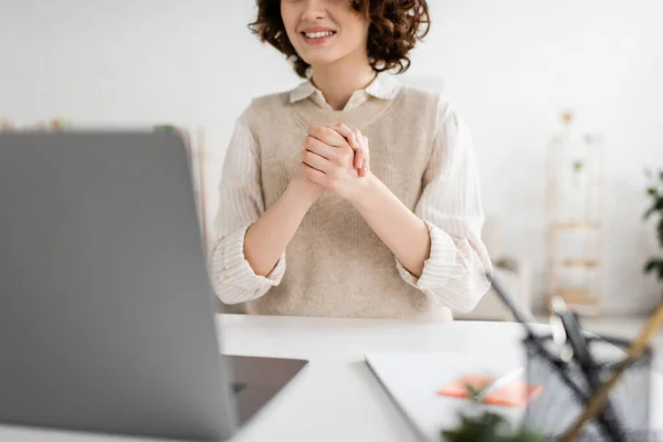 Cropped view of smiling woman talking on sign language during video chat on blurred laptop at home — Stock Photo