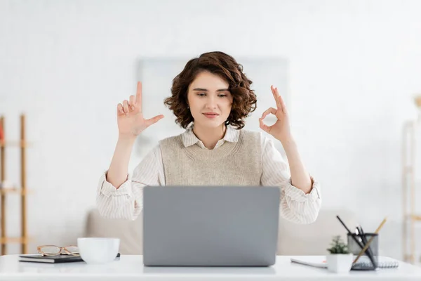 Curly sign language teacher showing alphabet letters during online lesson on laptop — Stock Photo