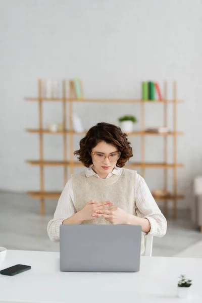 Young woman in eyeglasses showing name word in sign language during online lesson on laptop at home — Stock Photo