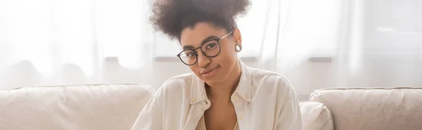 Femme afro-américaine souriante en lunettes regardant la caméra à la maison, bannière — Photo de stock